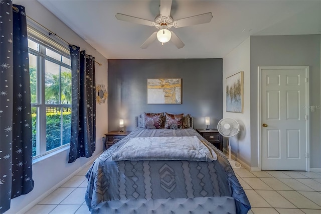 bedroom featuring a ceiling fan, baseboards, and light tile patterned floors