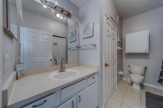 bathroom with tile patterned floors, baseboards, vanity, and toilet