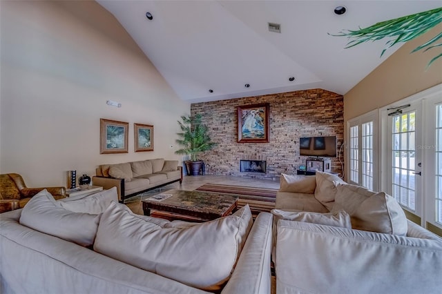 living area featuring a fireplace, visible vents, and high vaulted ceiling