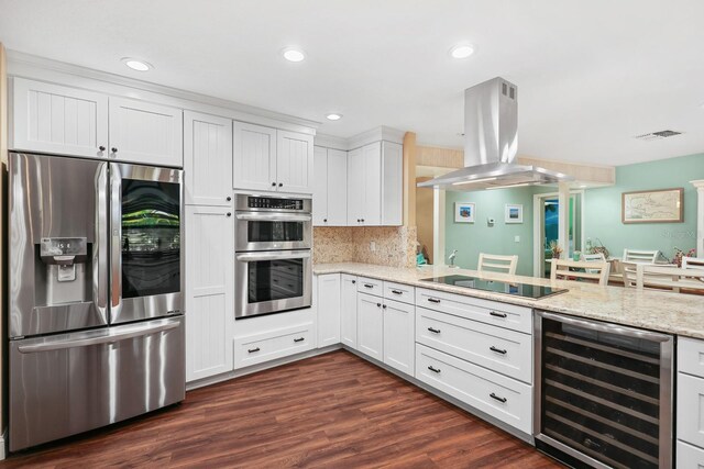 1004 Hollyberry Ct, Brandon, FL 33511 - kitchen with appliances with stainless steel finishes, beverage cooler, island range hood, white cabinets, and recessed lighting
