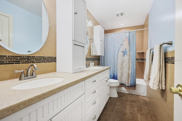 1004 Hollyberry Ct, Brandon, FL 33511 - bathroom with toilet, double vanity, tile walls, wood finished floors, and shower / bath combo with shower curtain