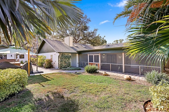 1004 Hollyberry Ct, Brandon, FL 33511 - view of front of property featuring a sunroom, a front lawn, a chimney, stucco siding, and roof with shingles