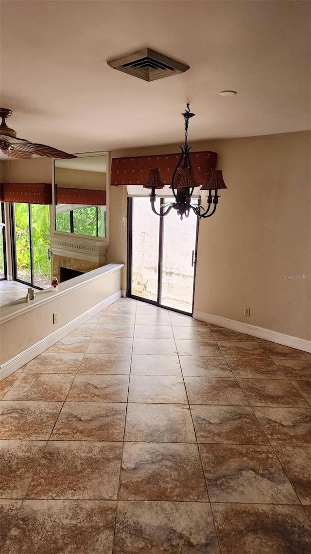 17115 Bay St, Jupiter, FL 33477 - unfurnished dining area with baseboards, visible vents, ceiling fan with notable chandelier, tile patterned flooring, and a fireplace