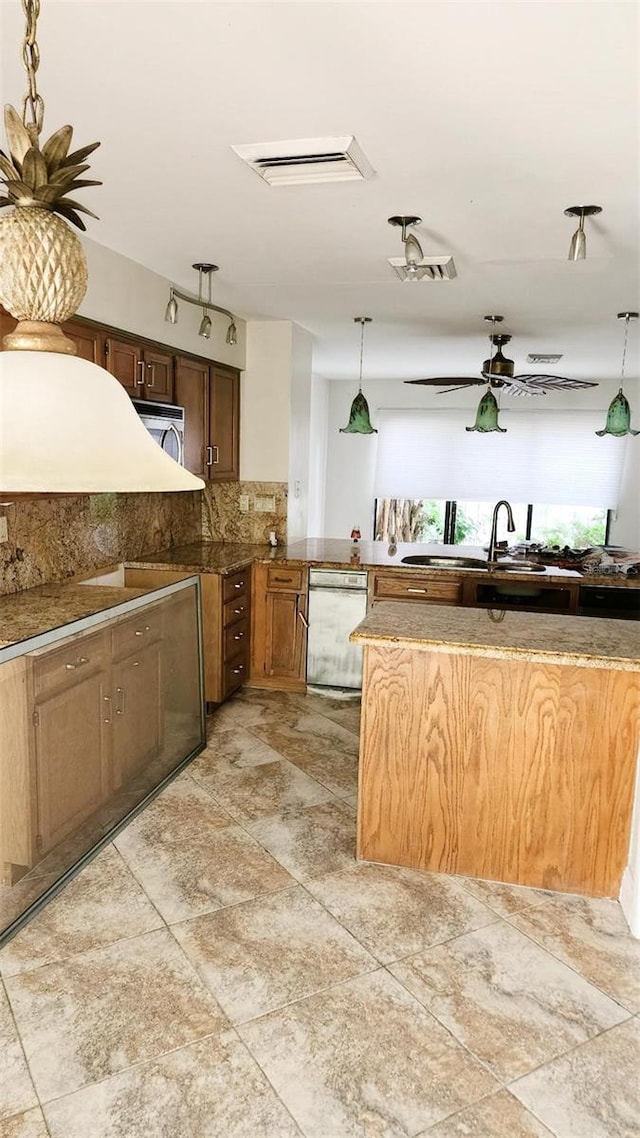 17115 Bay St, Jupiter, FL 33477 - kitchen with decorative backsplash, hanging light fixtures, a sink, and dishwashing machine