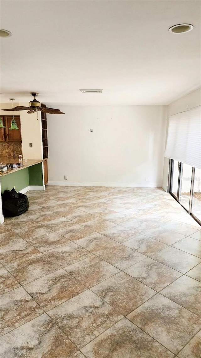17115 Bay St, Jupiter, FL 33477 - unfurnished living room with visible vents, baseboards, and ceiling fan