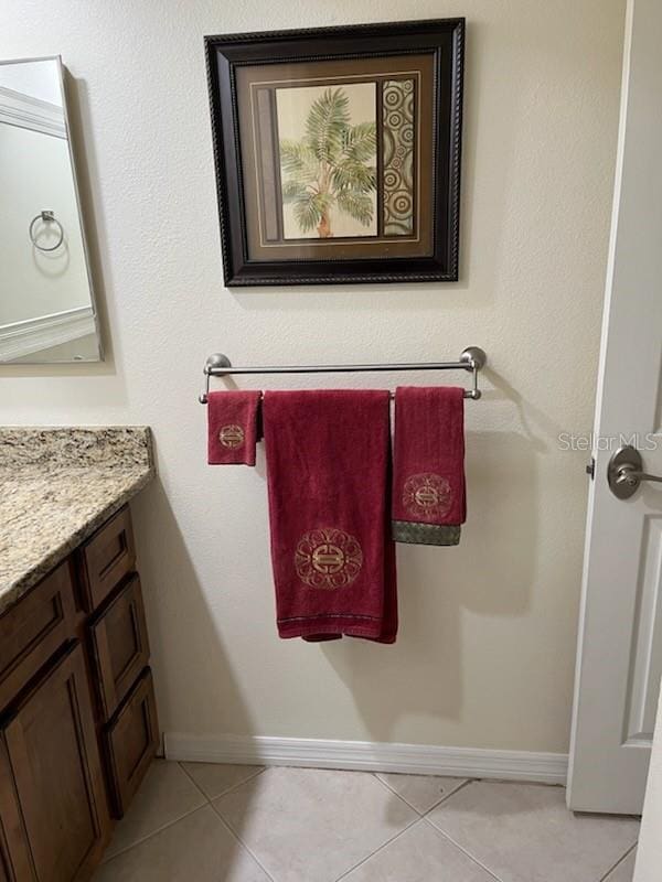 bathroom with tile patterned flooring, vanity, and baseboards