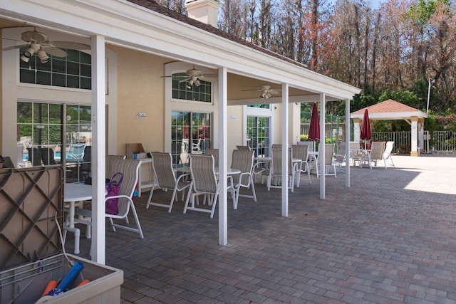 view of patio with fence, outdoor dining area, and a ceiling fan