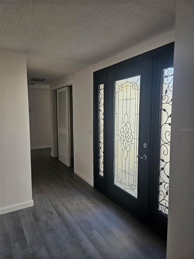 6241 Westport Dr, Port Richey, FL 34668 - foyer with wood finished floors, a textured ceiling, a healthy amount of sunlight, baseboards, and visible vents