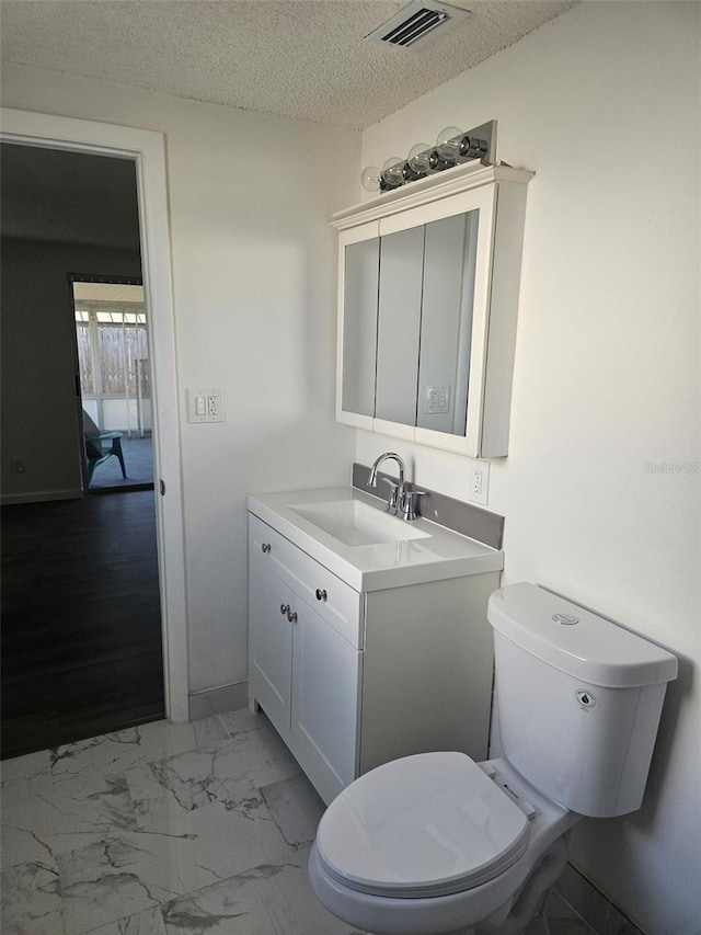 6241 Westport Dr, Port Richey, FL 34668 - bathroom with a textured ceiling, toilet, visible vents, marble finish floor, and vanity