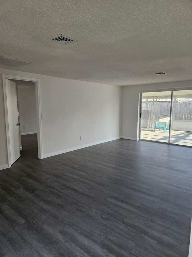 6241 Westport Dr, Port Richey, FL 34668 - unfurnished room with baseboards, dark wood-style flooring, a textured ceiling, and visible vents