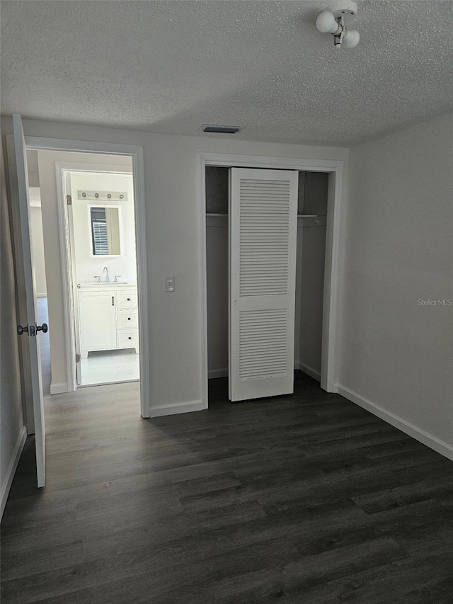 6241 Westport Dr, Port Richey, FL 34668 - unfurnished bedroom featuring baseboards, a textured ceiling, and dark wood-style floors