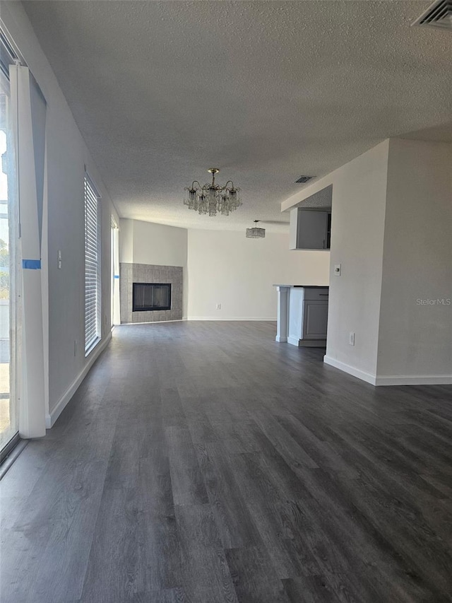 6241 Westport Dr, Port Richey, FL 34668 - unfurnished living room featuring a chandelier, a textured ceiling, dark wood-type flooring, and visible vents