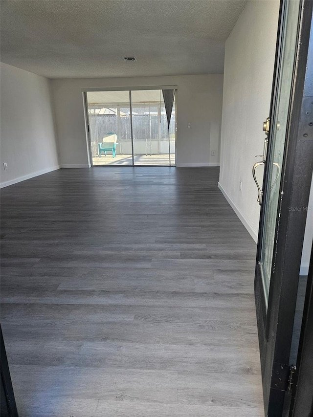 6241 Westport Dr, Port Richey, FL 34668 - spare room featuring wood finished floors, a textured ceiling, baseboards, and visible vents