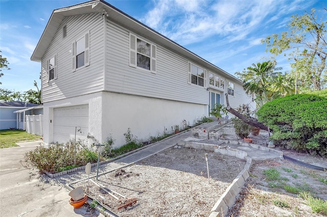 view of side of home with stucco siding and a garage
