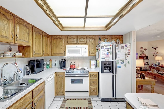 kitchen with light countertops, white appliances, a sink, and light tile patterned flooring