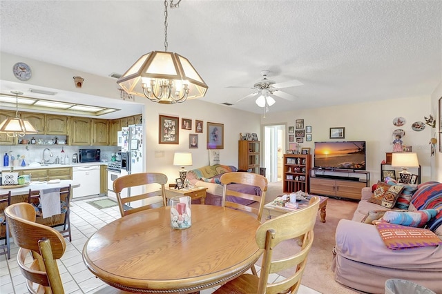 dining area featuring visible vents, a textured ceiling, and ceiling fan with notable chandelier