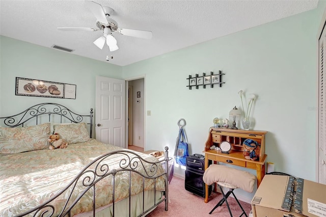 bedroom with light carpet, visible vents, a textured ceiling, and ceiling fan
