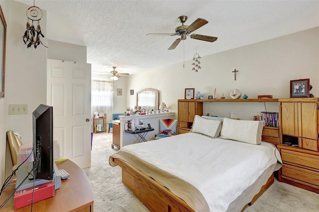 bedroom with a ceiling fan, a textured ceiling, and light colored carpet