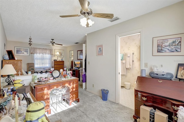 living area featuring a textured ceiling, visible vents, a ceiling fan, and light colored carpet