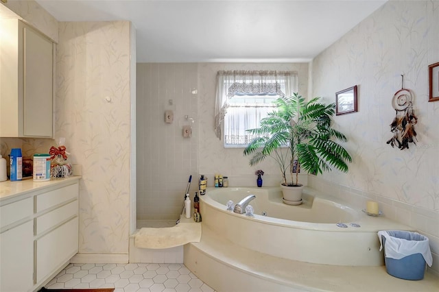 bathroom featuring tile patterned floors, a whirlpool tub, vanity, and wallpapered walls