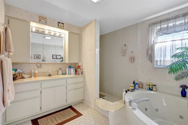 bathroom featuring a jetted tub, vanity, tile patterned floors, and tiled shower