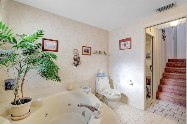 full bathroom featuring toilet, a tub with jets, wallpapered walls, and visible vents