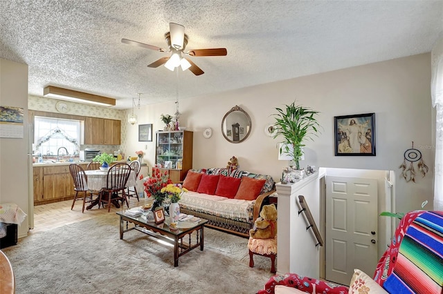 living area with ceiling fan and a textured ceiling