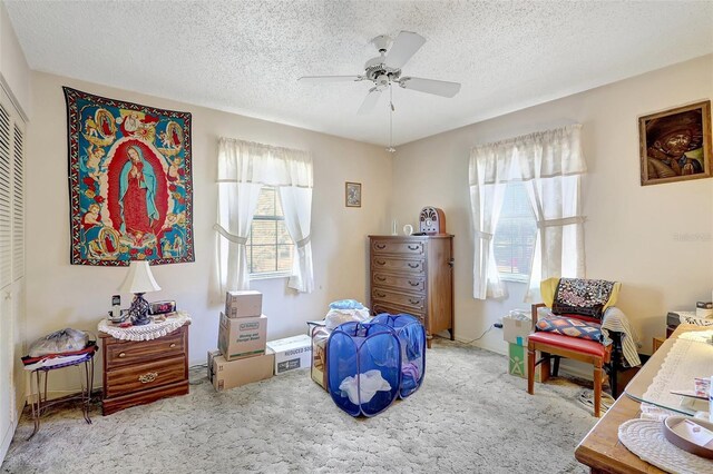 carpeted bedroom featuring a ceiling fan, a textured ceiling, and a closet