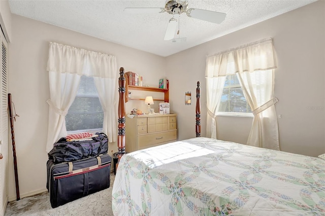 carpeted bedroom featuring a ceiling fan and a textured ceiling
