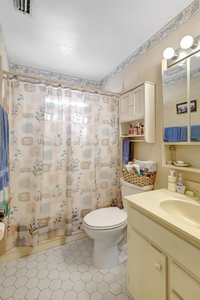 full bath featuring tile patterned flooring, visible vents, toilet, vanity, and shower / bath combo