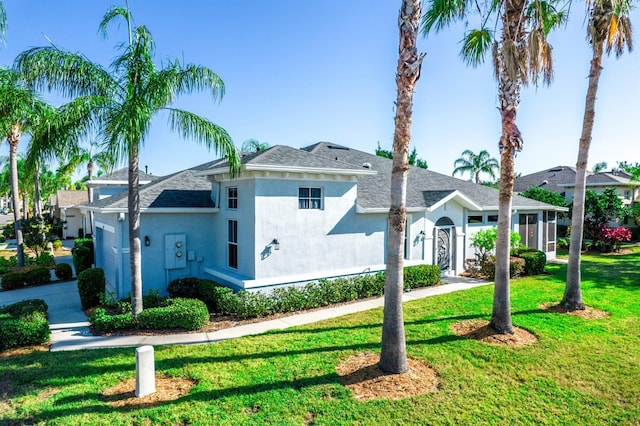 view of home's exterior featuring a shingled roof, a yard, and stucco siding