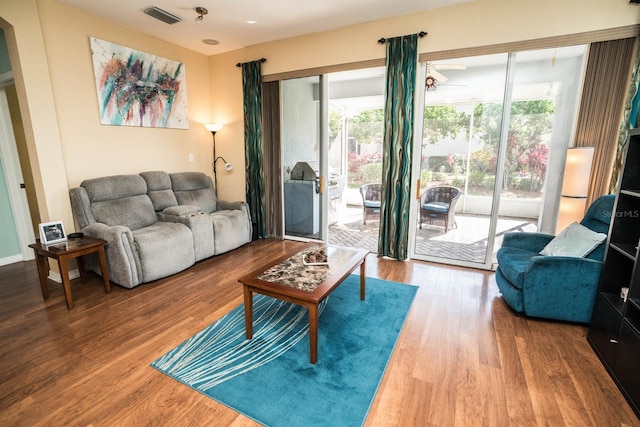 living area featuring a ceiling fan, wood finished floors, and visible vents