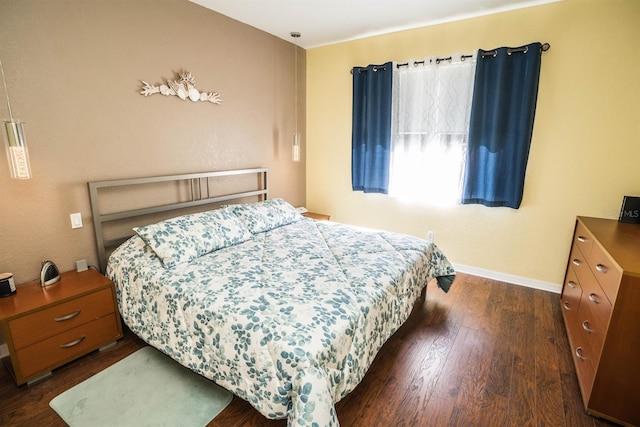 bedroom with baseboards and dark wood-type flooring