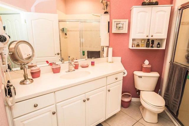 bathroom featuring vanity, toilet, a stall shower, and tile patterned floors
