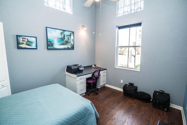 bedroom with dark wood finished floors, baseboards, and multiple windows