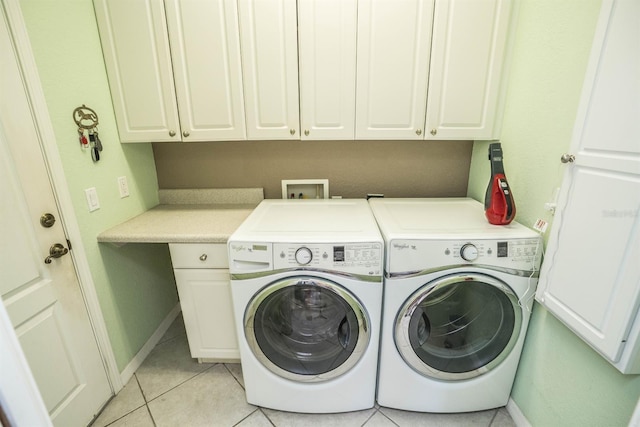 laundry room with separate washer and dryer, baseboards, light tile patterned flooring, and cabinet space