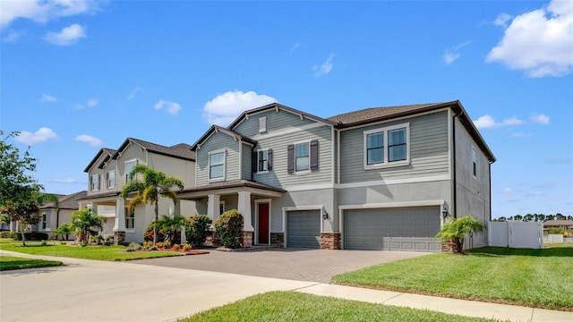 11720 Navajo Sandstone St, Riverview, FL 33579 - craftsman-style house with driveway, fence, a front lawn, an attached garage, and stone siding
