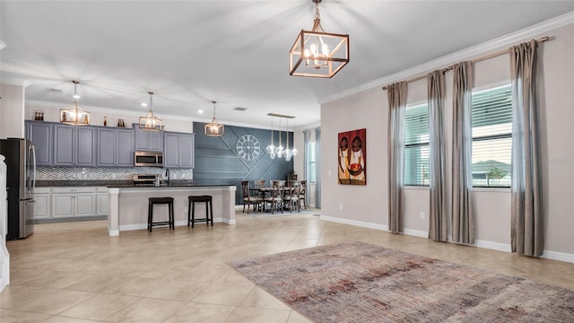 11720 Navajo Sandstone St, Riverview, FL 33579 - kitchen with crown molding, stainless steel appliances, a chandelier, and a breakfast bar