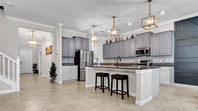 11720 Navajo Sandstone St, Riverview, FL 33579 - kitchen with a kitchen island with sink, gray cabinets, stainless steel appliances, decorative backsplash, and a kitchen bar