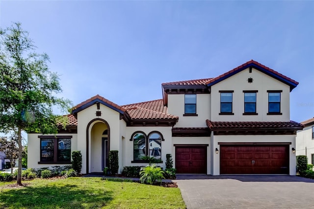 4975 Night Star Trl, Odessa, FL 33556 - mediterranean / spanish house featuring a garage, a tile roof, stucco siding, and a front yard