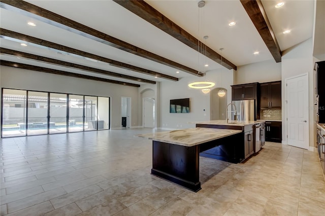 4975 Night Star Trl, Odessa, FL 33556 - kitchen featuring open floor plan, arched walkways, a center island with sink, beamed ceiling, and backsplash
