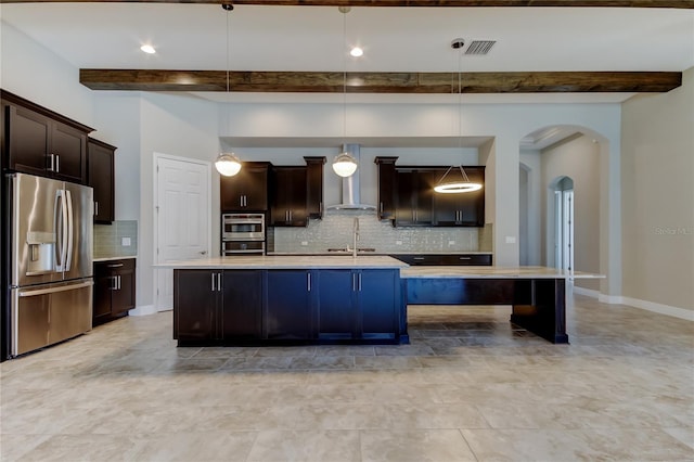 4975 Night Star Trl, Odessa, FL 33556 - kitchen featuring stainless steel appliances, wall chimney exhaust hood, beam ceiling, arched walkways, and light countertops