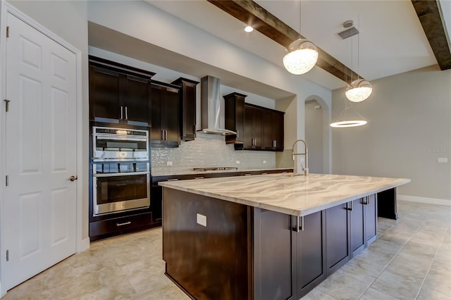 4975 Night Star Trl, Odessa, FL 33556 - kitchen featuring wall chimney exhaust hood, decorative backsplash, light stone counters, hanging light fixtures, and a center island with sink