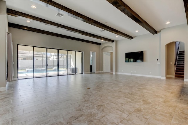 4975 Night Star Trl, Odessa, FL 33556 - unfurnished living room with arched walkways, beamed ceiling, baseboards, stairs, and recessed lighting
