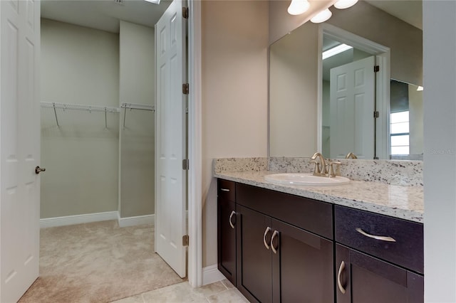 4975 Night Star Trl, Odessa, FL 33556 - bathroom with vanity, a spacious closet, and baseboards