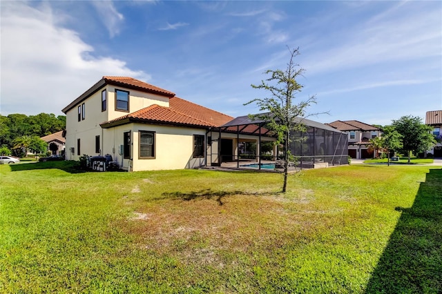 4975 Night Star Trl, Odessa, FL 33556 - rear view of property featuring a tiled roof, stucco siding, a lawn, and glass enclosure