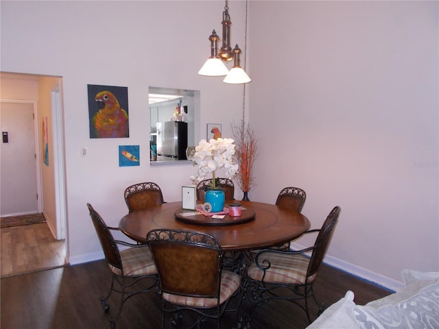 dining space featuring wood finished floors and baseboards