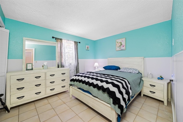 bedroom with a textured ceiling and light tile patterned floors