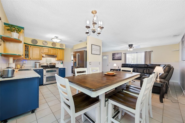 dining area with ceiling fan with notable chandelier, a textured ceiling, and light tile patterned floors