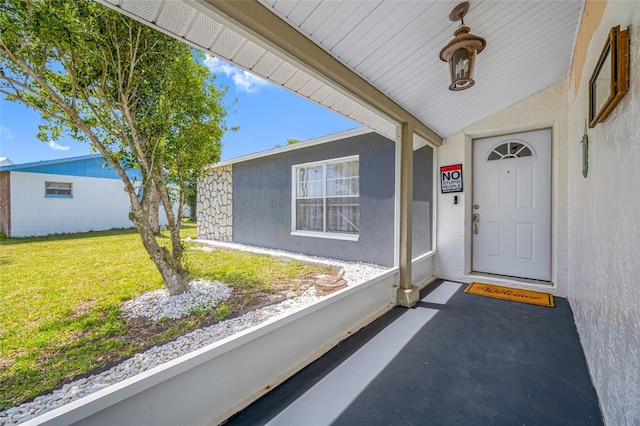 doorway to property featuring a yard and stucco siding